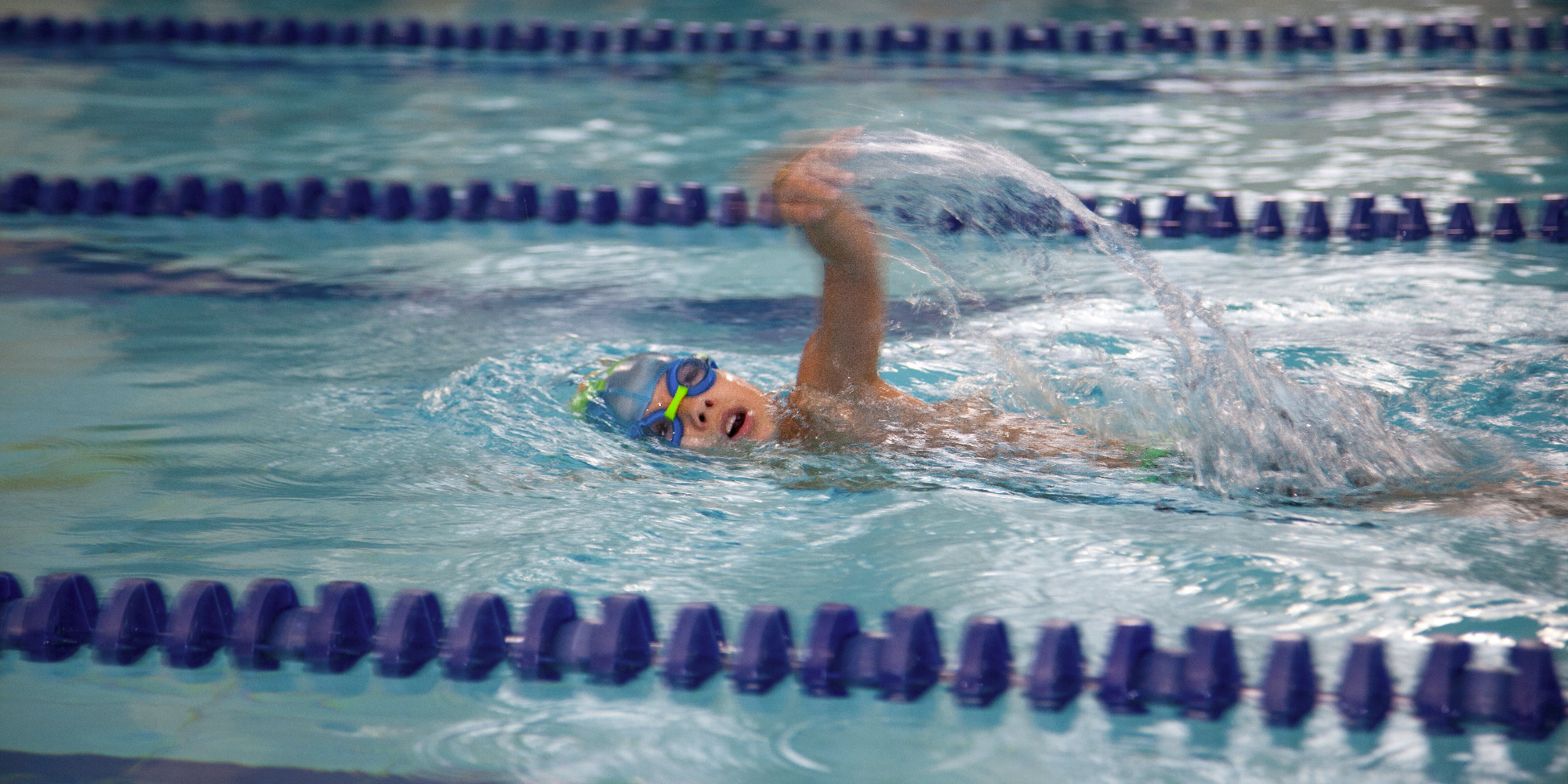 Natation pour enfant. L'enfant nage dans la piscine